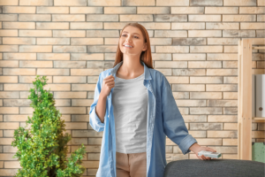 woman wearing a white shirt wtih a chambray shirt on top of it with fair skin standing smiling because she recovered from PPPD